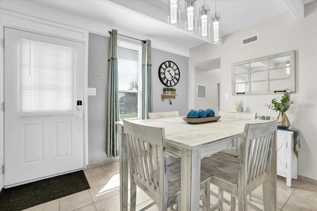 tiled dining space featuring beamed ceiling