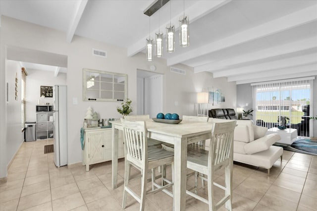 tiled dining room featuring beam ceiling