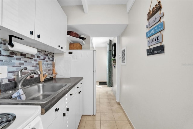 kitchen featuring decorative backsplash, light tile patterned flooring, white cabinetry, and sink