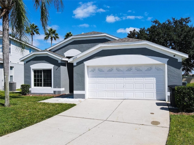 ranch-style home featuring a front yard, a garage, and central AC unit