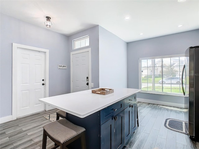 kitchen featuring light hardwood / wood-style flooring, plenty of natural light, and a kitchen island