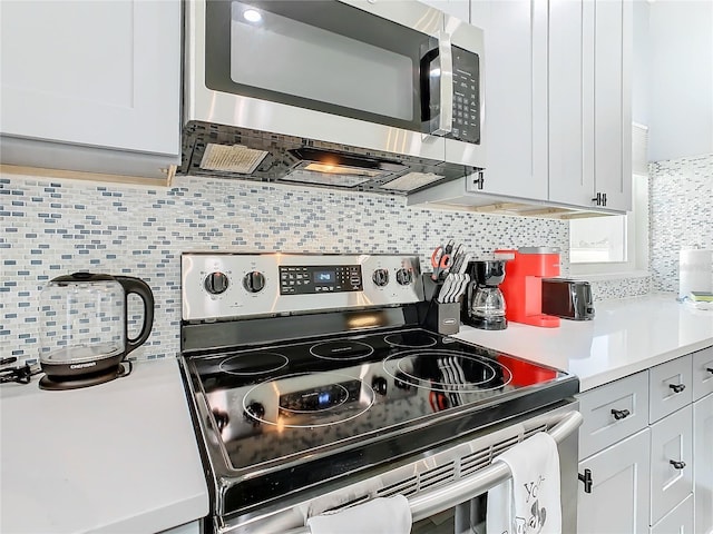 kitchen featuring white cabinets, appliances with stainless steel finishes, and tasteful backsplash