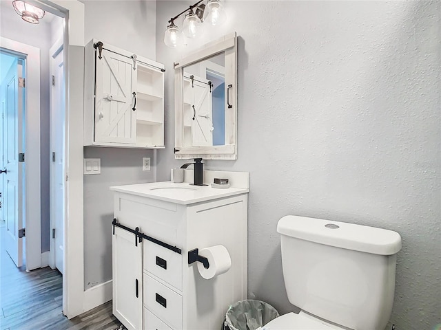 bathroom featuring vanity, hardwood / wood-style floors, and toilet