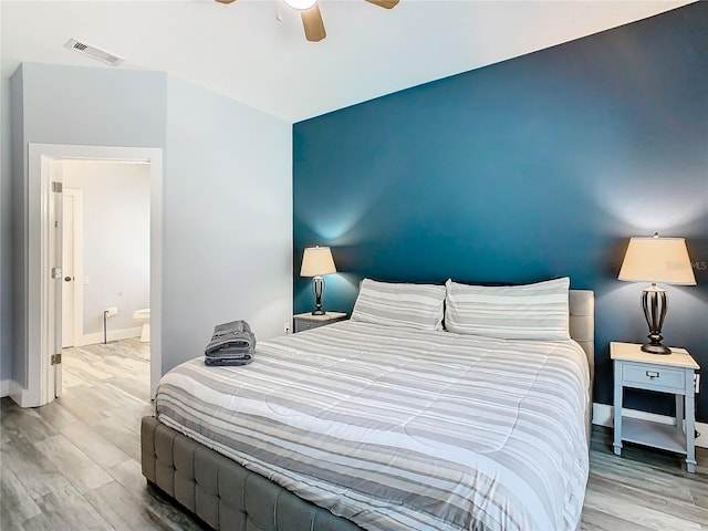 bedroom with ceiling fan, hardwood / wood-style flooring, and ensuite bathroom