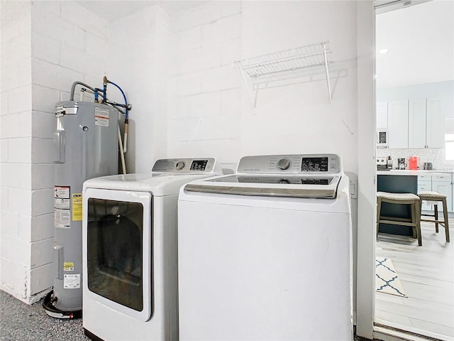 washroom with electric water heater and washer and clothes dryer