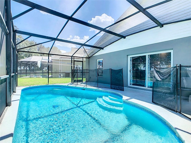 view of pool with a patio, a yard, and a lanai