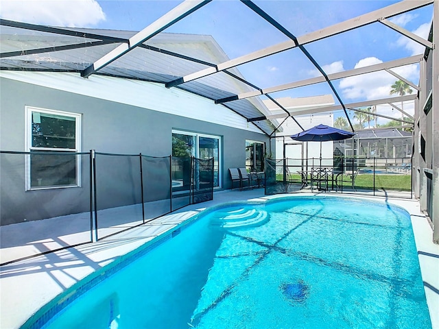 view of pool with a patio and glass enclosure