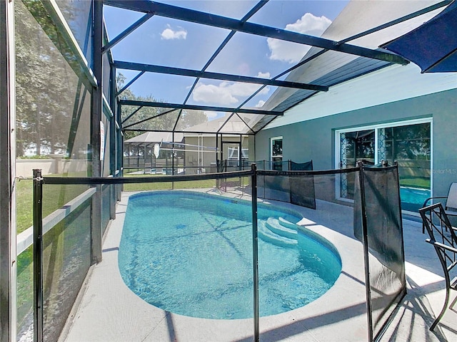 view of pool featuring glass enclosure and a patio area