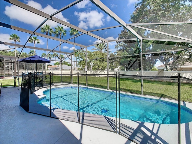 view of pool with a lawn, a patio, and glass enclosure