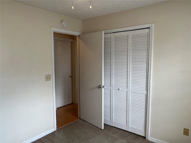 unfurnished bedroom featuring carpet, a closet, and a textured ceiling