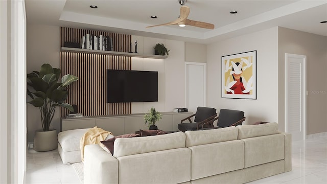 living room with a raised ceiling and ceiling fan