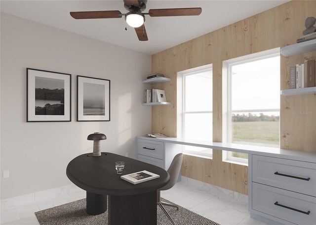 office space featuring ceiling fan and wooden walls