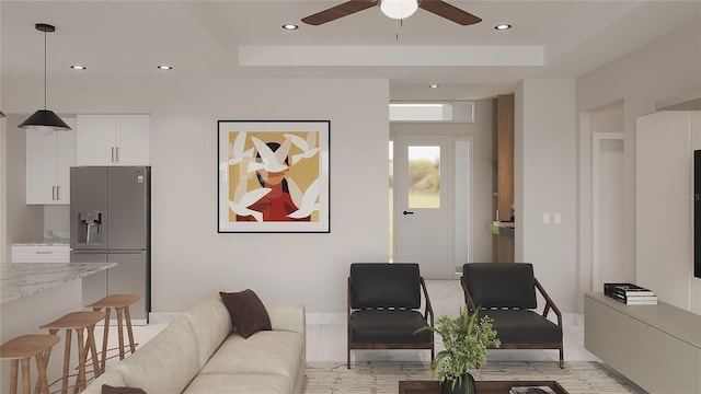 living room with a tray ceiling and ceiling fan