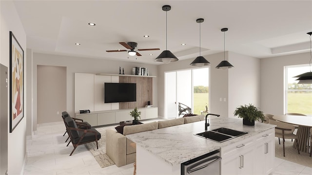 kitchen with white cabinets, a kitchen island with sink, plenty of natural light, and sink