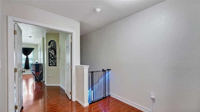 hall featuring hardwood / wood-style flooring and a textured ceiling