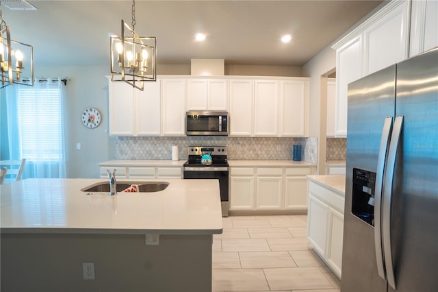 kitchen with an island with sink, stainless steel appliances, and a chandelier