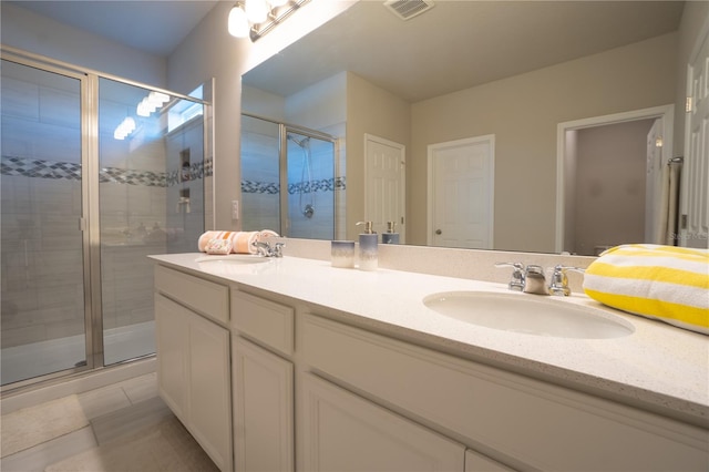 bathroom with tile patterned flooring, vanity, and a shower with shower door