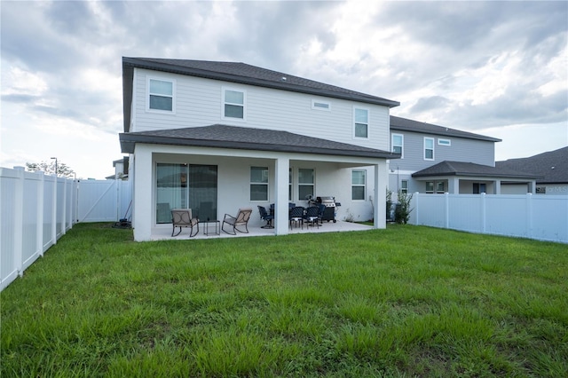 rear view of property with a lawn and a patio