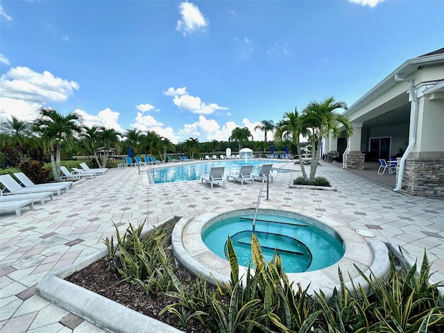 view of swimming pool featuring a patio area and a community hot tub