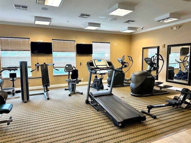 exercise room with carpet flooring, ornamental molding, and a textured ceiling