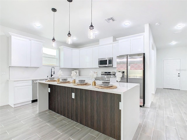 kitchen with a center island, appliances with stainless steel finishes, and white cabinetry