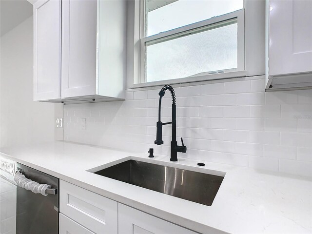 kitchen with sink, white cabinets, decorative backsplash, and dishwasher