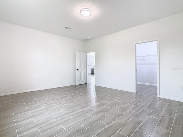 unfurnished room featuring light hardwood / wood-style floors and a textured ceiling