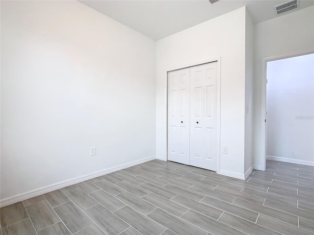 unfurnished bedroom with light hardwood / wood-style flooring and a closet