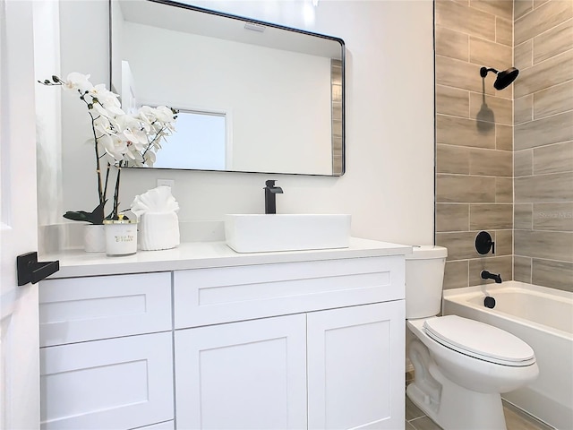 full bathroom featuring vanity, tiled shower / bath combo, toilet, and tile patterned flooring