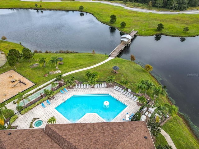 view of pool featuring a patio area, a water view, and a lawn