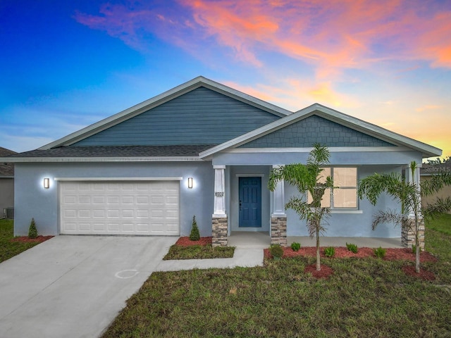 view of front of property with central AC, a garage, and a lawn