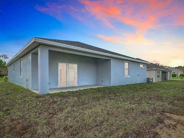 property exterior at dusk with a yard