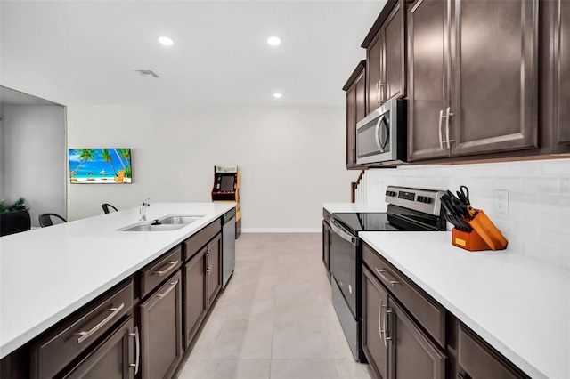 kitchen featuring sink, decorative backsplash, stainless steel appliances, dark brown cabinetry, and light tile patterned floors