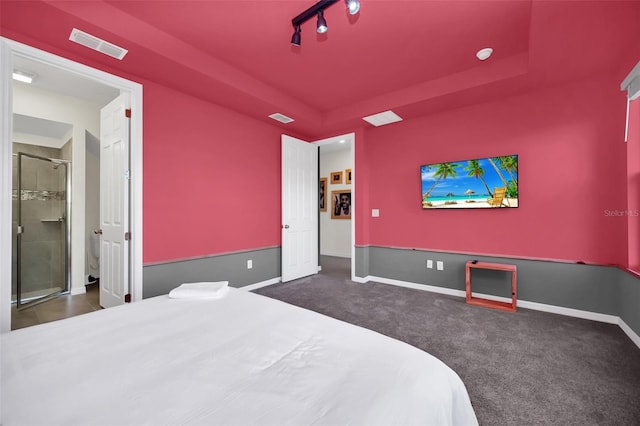 bedroom with dark carpet and rail lighting