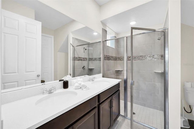 bathroom featuring walk in shower, vanity, toilet, and tile patterned floors