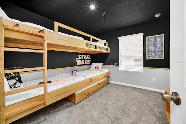 bedroom featuring a textured ceiling, carpet flooring, and rail lighting