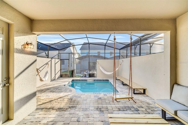 view of swimming pool with a lanai and a patio area