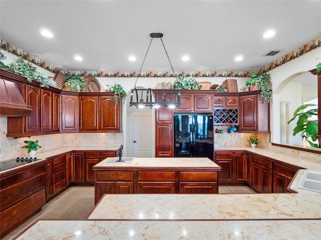 kitchen with a sink, visible vents, light countertops, black appliances, and decorative light fixtures