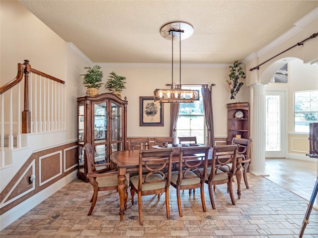 dining room featuring a healthy amount of sunlight, arched walkways, and wainscoting