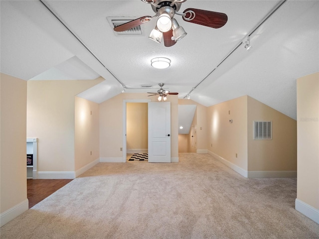 bonus room with visible vents, vaulted ceiling, and light carpet