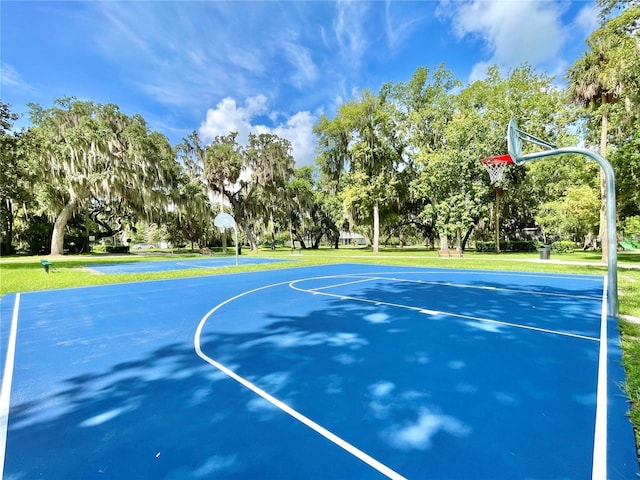 view of basketball court with community basketball court and a lawn