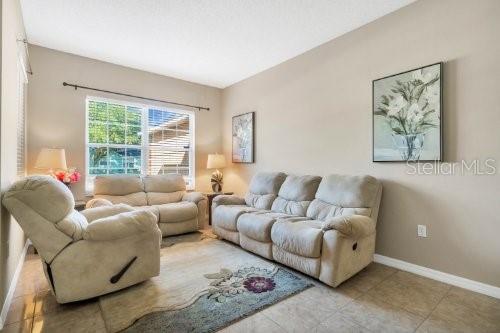living room with tile patterned flooring and baseboards