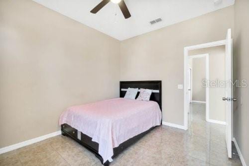 bedroom featuring light tile patterned flooring, visible vents, ceiling fan, and baseboards