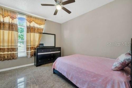 tiled bedroom with ceiling fan