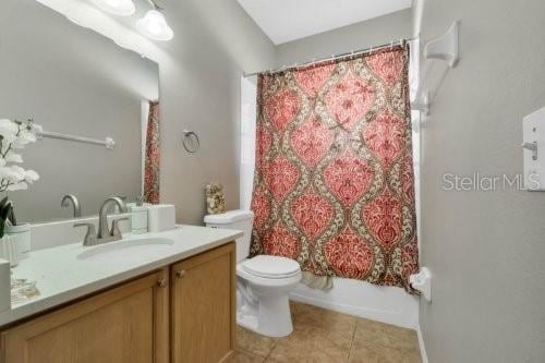 bathroom with shower / bath combination with curtain, toilet, tile patterned flooring, and vanity