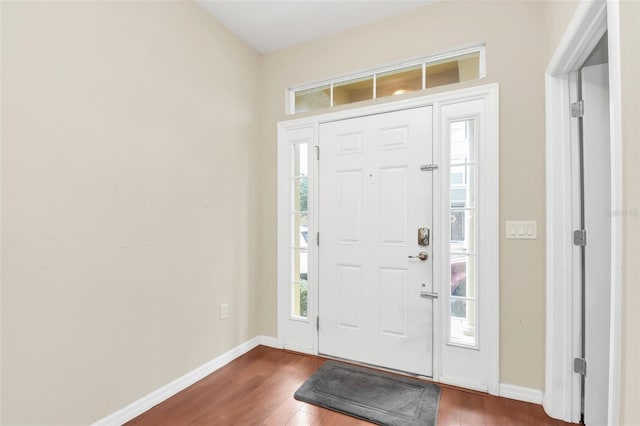 entryway with a wealth of natural light, wood finished floors, and baseboards