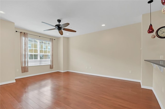 empty room with recessed lighting, baseboards, ceiling fan, and wood finished floors