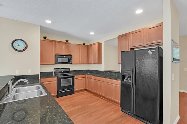kitchen with recessed lighting, black appliances, light wood-style flooring, and a sink