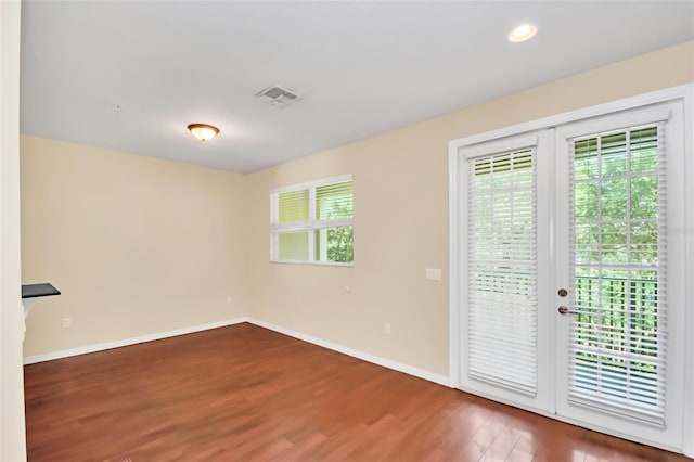 unfurnished room featuring baseboards, visible vents, wood finished floors, and recessed lighting