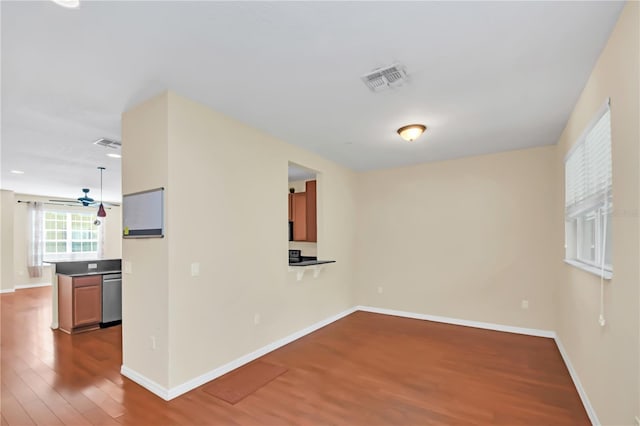 empty room featuring baseboards, visible vents, and wood finished floors
